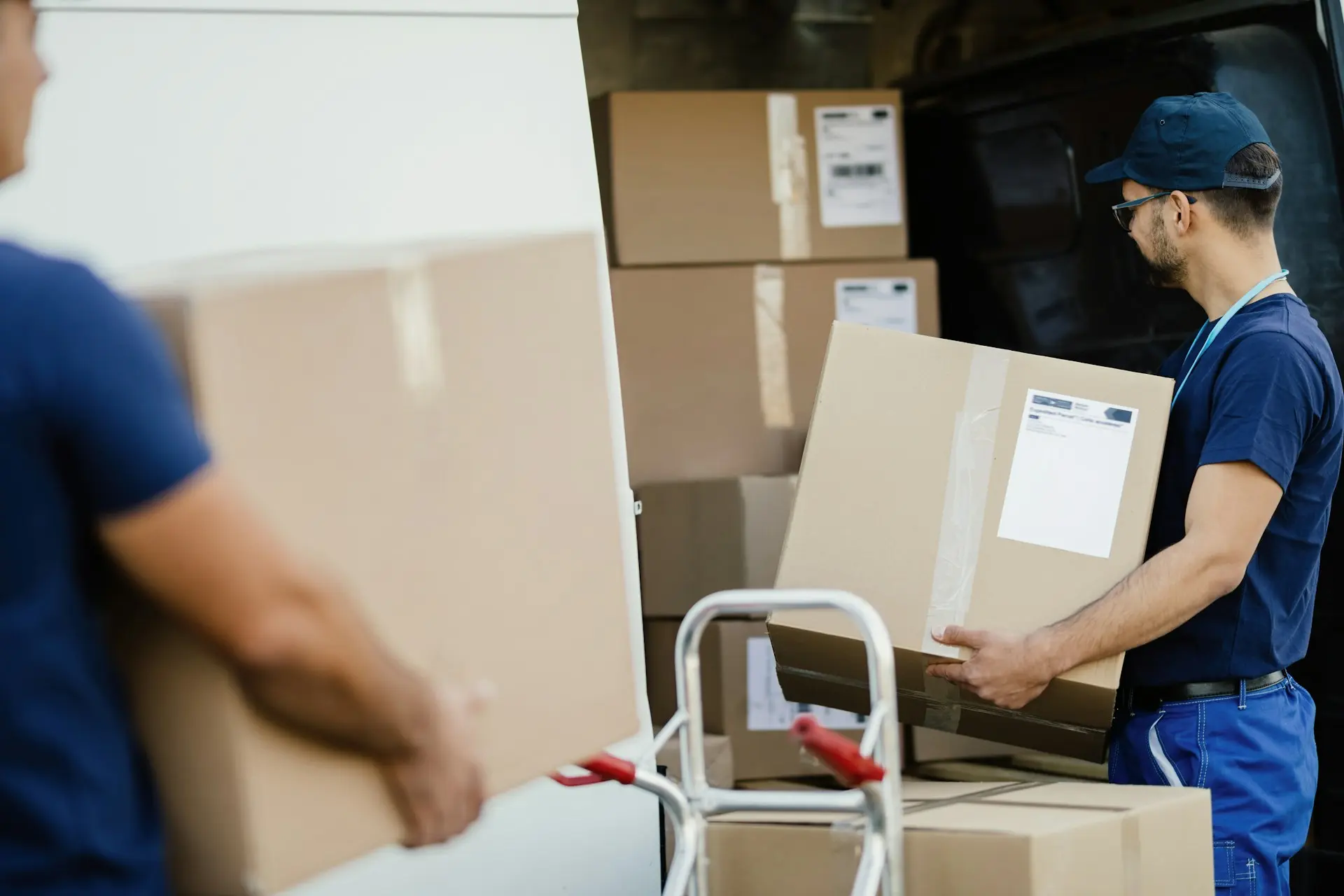 Möbelpacker tragen ein Möbelstück zum Umzugswagen