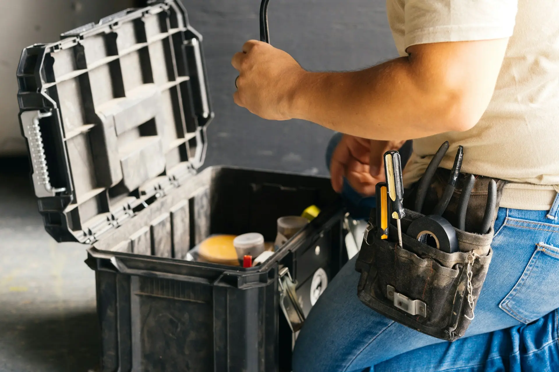 Hausmeister nimmt Werkzeug aus dem Werkzeugkasten für eine Kleinreparatur