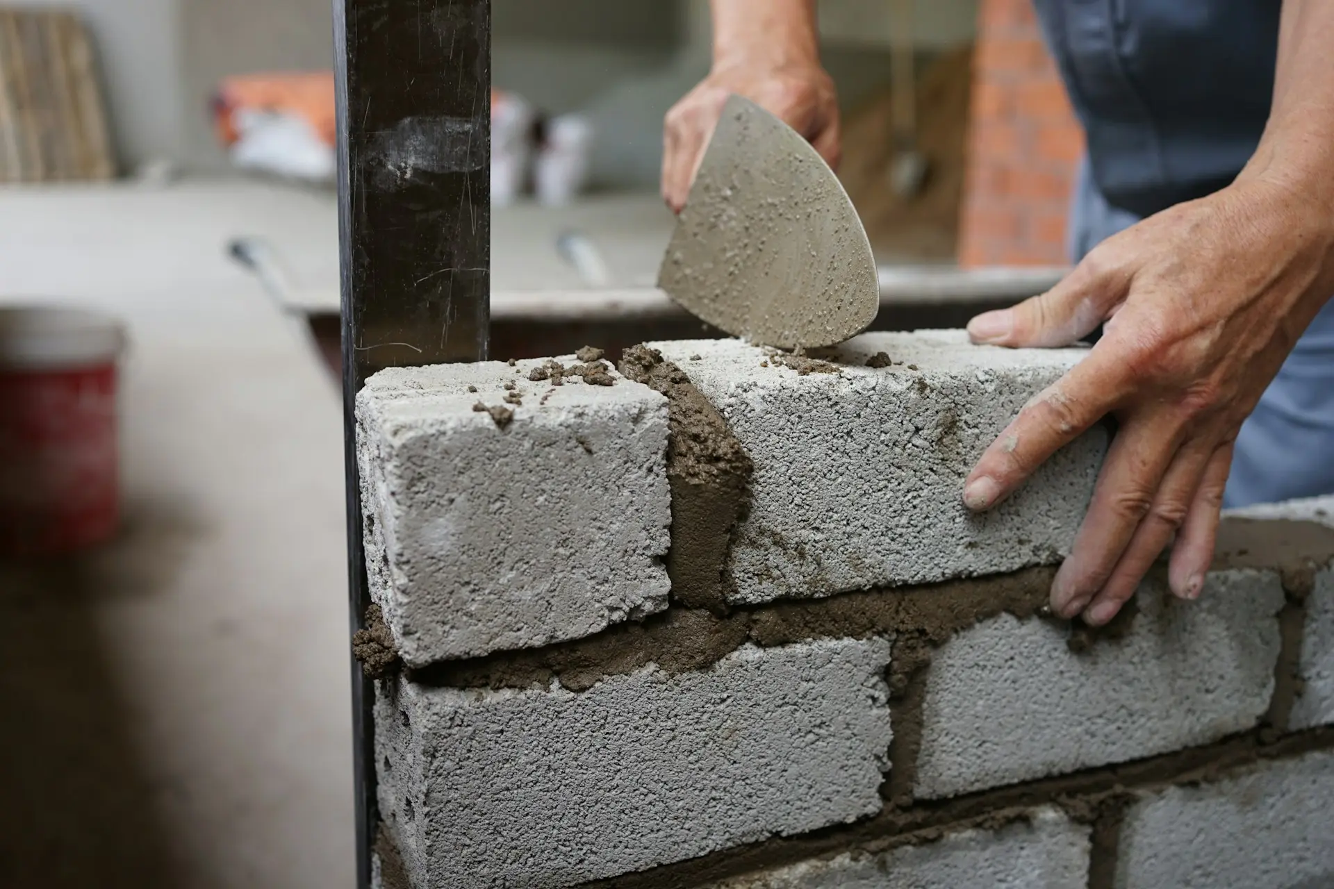 Maurer setzt einen Stein auf eine Mauer auf der Baustelle
