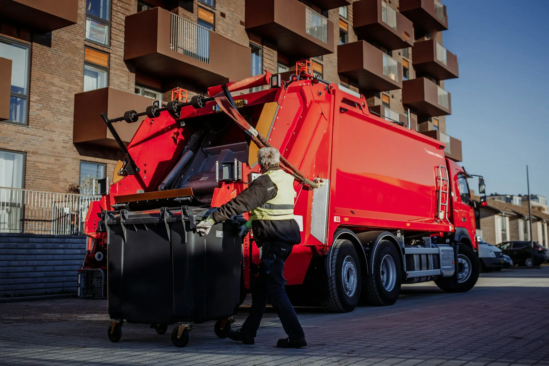 Müllwerker leert eine Mülltonne in den Entsorgungswagen